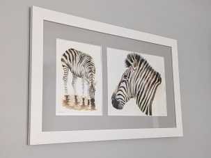 Zebra paintings in mounted frame at an angle